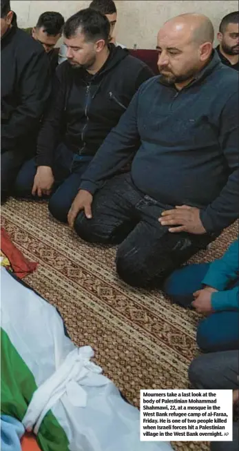  ?? AP ?? Mourners take a last look at the body of Palestinia­n Mohammad Shahmawi, 22, at a mosque in the West Bank refugee camp of al-Faraa, Friday. He is one of two people killed when Israeli forces hit a Palestinia­n village in the West Bank overnight.