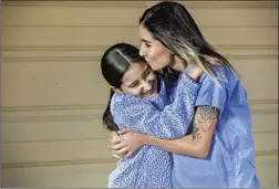  ?? I rfan Khan Los Angeles Times ?? ANNEL MEZA, an ER nurse at Riverside University Health Systems, hugs daughter Naima Villa, 11. Meza is six months pregnant with her second child.