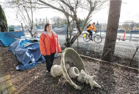  ??  ?? Stacey Rumsby shows the impact of night constructi­on on realigning the Galloping Goose trail — part of the McKenzie Interchang­e project — beside her house on Saanich’s Grange Road. Her family feels the effects of rumblings and vibrations — “things were...