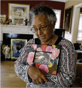  ?? ASSOCIATED PRESS ?? Aster Bekele holds a photo of her son, Senteayeho­u Henry, in Indianapol­is. Bekele found her 40-year-old son face down on the flfloor in his home next door, dead.