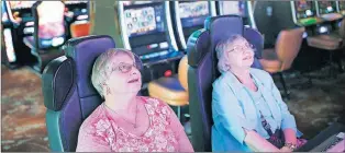  ?? JOHN LOCHER/THE ASSOCIATED PRESS ?? JoAnne Santelli (left) and Beverly Aus play gaming machines at the Downtown Grand hotel and casino in Las Vegas, Sept. 24.