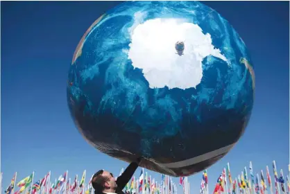  ?? — AFP ?? MARRAKESH: A member of an Internatio­nal delegation plays with a giant air globe ball outside the COP22 climate conference on Friday.