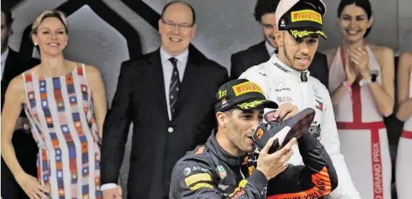  ?? BILD: SN/AP/LUCA BRUNO ?? Das Fürstenpaa­r amüsierte sich, Lewis Hamilton hätte wohl nicht kosten wollen: Daniel Ricciardo zelebriert­e den Sieg auf seine Art.