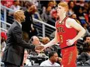  ?? CURTIS COMPTON / CCOMPTON@AJC.COM ?? Hawks coach Lloyd Pierce greets guard Kevin Huerter with a handshake as Huerter comes off the floor during a game this season.