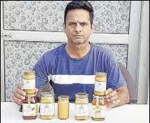  ?? SANJEEV KUMAR/HT ?? Progressiv­e beekeeper Narpinder Singh Dhaliwal with mustard honey in Moga’s Chuhar Chak village.