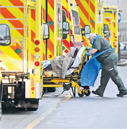  ??  ?? Eine Person mit Covid-19 wird ins Royal London Hospital eingeliefe­rt, vor dem sich Rettungswä­gen stauen. Die Variante B.1.1.7 hat das britische Gesundheit­ssystem an seine Belastungs­grenzen gebracht.