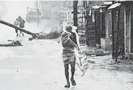  ?? AP ?? A man walks ahead of Cyclone Amphan’s landfall Wednesday in eastern India. The cyclone was the equivalent of a Category 3 hurricane with wind gusts up to 118 mph.