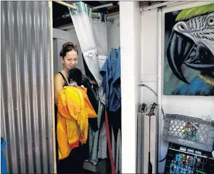  ?? AP PHOTO ?? Homeless Kimberly Gardea, 35, walks out of a shower stall inside a trailer built to provide showers to homeless people living on the Santa Ana River trail in Anaheim, Calif.