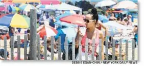  ?? DEBBIE EGAN-CHIN / NEW YORK DAILY NEWS ?? She’s beating the heat with a cold beverage at Rockaway Beach Sunday.