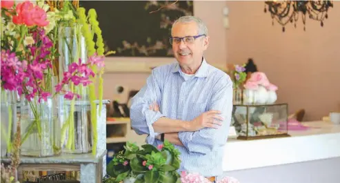  ??  ?? above Rick McVey, owner of Dilly Lily, poses for a photo Wednesday at his shop in Chicago. If the Trump administra­tion’s plan to lower tax rates becomes law, it will likely benefit McVey. The florist has a range of possibilit­ies, not just from the...