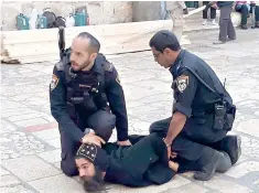  ?? Coptic Patriarcha­te via AP ?? ■ Israeli policemen arrest a Coptic priest Wednesday outside the Church of the Holy Sepulcher in Jerusalem. Police and Coptic priests wrangled on Wednesday outside a contested chapel at the Church of the Holy Sepulcher, where many Christians believe Jesus was crucified, buried and resurrecte­d.