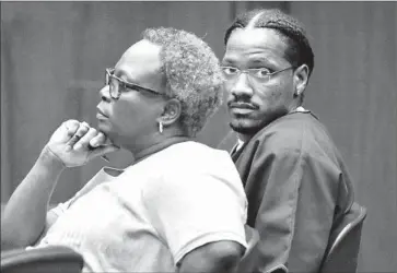  ?? Photograph­s by
Al Seib
Los Angeles Times ?? LEONARD HALL, 26, sits in a downtown Los Angeles courtroom Tuesday beside his attorney, Carol Ojo, as he is sentenced for his role in the 2010 killing. A co-defendant in the attack had named Hall as the shooter.