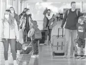  ?? DAVID ZALUBOWSKI/AP ?? Travelers check in at a ticket counter Dec. 31 at Denver Internatio­nal Airport.