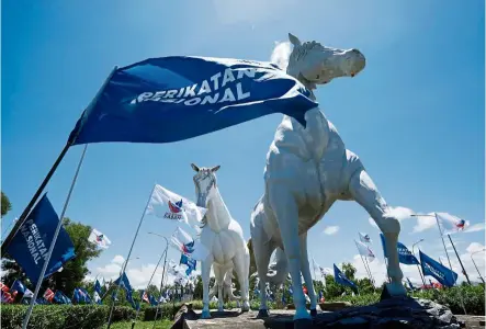  ?? — ZULAZHAR SHEBLEE/The Star ?? Dash for the finish line: Party flags placed all around the Tuaran roundabout centrepiec­e. Horses are a symbol of pride for the Tuaran community.