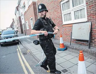  ?? JACK TAYLOR
GETTY IMAGES ?? A police officer fixes police tape across a street in Salisbury after a major incident was declared when a man and woman were exposed to the Novichok nerve agent on July 5.