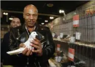 ?? NICK UT — THE ASSOCIATED PRESS ?? In this Jan. 29 photo, former boxing champion Mike Tyson holds a white homing pigeon at the National Pigeon Associatio­n’s 93rd annual Grand National Pigeon Show in Ontario, Calif.