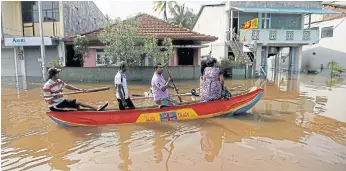  ??  ?? COME HELL OR HIGH WATER: People move in a boat on a flooded road in Nagoda village.