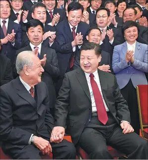  ?? LI XUEREN / XINHUA ?? President Xi Jinping takes the hand of Huang Xuhua, 93, an academicia­n at the Chinese Academy of Engineerin­g who played a key role in developing China’s nuclear-powered submarines. Huang was among 600 individual­s being honored for their work promoting...