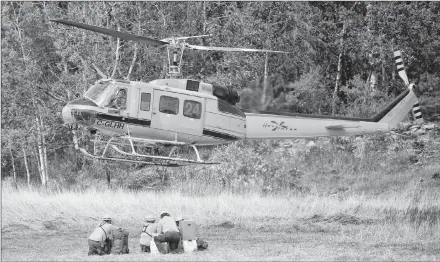  ?? CP PHOTO ?? A helicopter lands to pick up Mexican fire rangers where the Parry Sound 33 forest fire has burnt thousands of hectares of land near Britt, Ont., earlier this week.