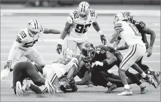  ?? TOM PENNINGTON/GETTY ?? C.J. Goodwin recovers an onside kick with 1:48 left in the Cowboys’ victory over the Falcons on Sunday.