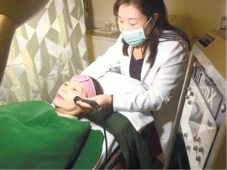  ?? (CONTRIBUTE­D FOTO) ?? SPECIAL TREATMENT. Doctor Leilani Ruiz Aquino performs a facial treatment using the radio frequency machine. Being the business for 26 years, those behind the Ruiz Derma and Cosmetic Center believe they have an edge over bigger players in the health...