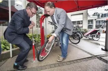  ?? BERNARD WEIL/TORONTO STAR ?? TTC chief customer officer Chris Upfold, left, and chairman Josh Colle test out the Davisville bicycle repair station.