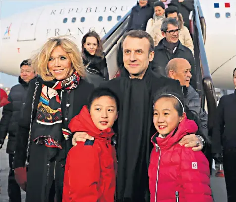  ??  ?? Emmanuel Macron and the first lady pose with children as they are welcomed at Beijing’s Capital Airport. Left, Vesuvius, a Republican Guard horse, a gift to the Chinese leader