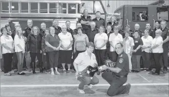  ?? KATHY JOHNSON ?? With their peers in the background, IBPFD Support Group President Vera Penney and IBPFD Deputy-Chief Corey Crowell pose with the new battery-operated jaws of life purchased by the Support Group for the department.