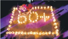  ??  ?? A man lights lamps to form the number 60, representi­ng the 60 minutes of Earth Hour, during Earth Hour in Colombo, Sri Lanka. — Reuters photo