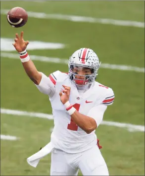  ?? Al Goldis / Associated Press ?? Ohio State quarterbac­k Justin Fields throws a pass during an NCAA football game against Michigan State on Saturday in East Lansing, Mich. Ohio State won 52-12.