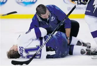  ?? Elise Amendola/the Associated Press ?? Tampa Bay Lightning’s Steven Stamkos lies on the ice in pain after banging into the goalpost during a game against Boston in November. He is now skating in full gear as he recovers from a broken leg.