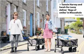  ?? Greg Martin ?? > Tamsin Harvey and Sarah De-Lacey deliver ‘Bags of smiles’ in Mousehole
