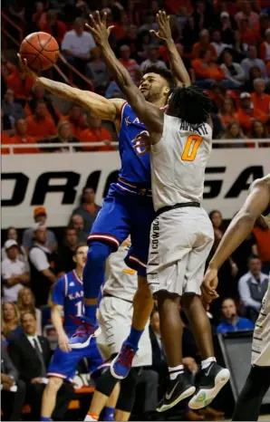  ??  ?? FROM LEFT: Kansas guard Frank Mason III shoots in front of Oklahoma State guard Brandon Averette in the second half of an NCAA college basketball game Saturday in Stillwater, Okla. Kansas won 90-85. AP PHOTO