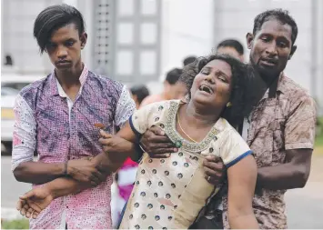  ??  ?? TERRIBLE LOSS OF LIVES: Relatives of a blast victim grieve outside a morgue in Colombo, Sri Lanka.