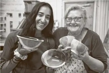  ?? Leah Gerber ?? Aleena Singh and June Macdonald of the Waterloo Potters’ Workshop hold up some of the bowls they’ve made for the Empty Bowls fundraiser for the Food Bank of Waterloo Region.