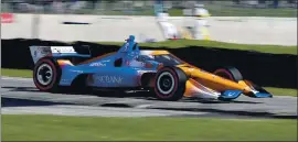  ?? GARY C. KLEIN — THE ASSOCIATED PRESS ?? Driver Scott Dixon is a blur of speed as he exits Turn 5 during Saturday’s Indycar race in Elkhart Lake, Wis. Dixon went on to win. The series races at Road America again today.