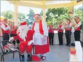  ??  ?? Father and Mother Christmas with canine friends joined the Dannevirke Brass Band in the Fountaine Square rotunda.