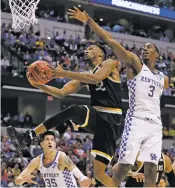  ?? ASSOCIATED PRESS FILE PHOTO ?? Wichita State’s Markis McDuffie, center, heads to the basket on March 19 during a second-round game in the NCAA Tournament against Kentucky in Indianapol­is.