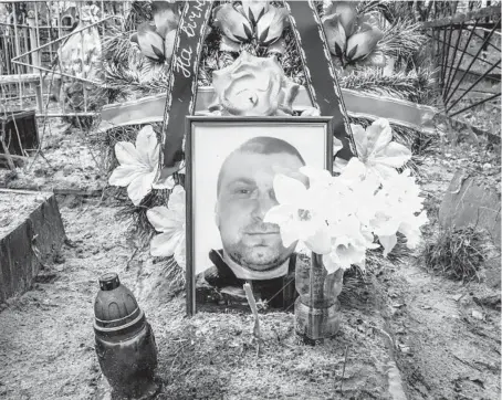  ?? DANIEL BEREHULAK/THE NEW YORK TIMES PHOTOS ?? A photo of Oleh Abramova, who was executed by Russian forces March 5, adorns his grave in Bucha, Ukraine.