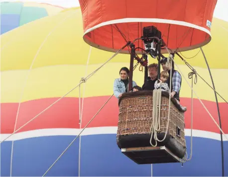  ?? Tyler Sizemore / Hearst Connecticu­t Media ?? Kayla Nieuwoudt and Silas Moore, 6, left, and Rick Sullivan and Teddy Sullivan, 4, right, ride on a hot air balloon with pilot Bill Colyer, center, at the Greenwich Land Trust's 19th annual Go Wild! Family Field Day at the Greenwich Polo Club in Greenwich in 2018.