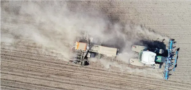  ?? Foto: dpa/Patrick Pleul ?? Auf einem Maisfeld bei Jacobsdorf im Landkreis Oder-Spree wirbelt ein Traktor beim Drillen eine mächtige Staubwolke auf.