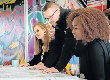  ??  ?? EYE-CATCHING: SVA Internatio­nal architects, from left, Judy Cizek, Gordon Barnard and Zintle Ndyambo hard at work in the firm’s Port Elizabeth office. The graffiti-inspired mural in the background was created by local artist Steven ‘Joff’ Carter
