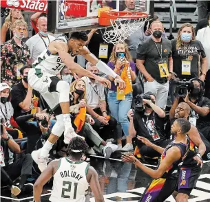  ?? CHRISTIAN PETERSEN GETTY IMAGES ?? Giannis Antetokoun­mpo of the Milwaukee Bucks dunks against Chris Paul of the Phoenix Suns during Game 5 of the NBA Finals at Footprint Center in Phoenix on Saturday night.