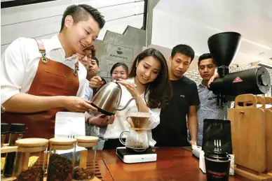  ?? GUSLAN GUMILANG/JAWA POS ?? PRAKTIK SAMBIL DISKUSI: Irvan Gunawan (kiri) sharing cara menyeduh kopi secara manual di Monopole Coffee Lab.