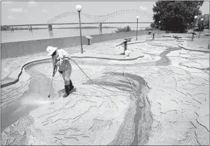 ?? NIKKI BOERTMAN/THE
COMMERCIAL APPEAL ?? Amanda Glenn power washes dirt and debris
from the Mud Island River Park’s
Riverwalk Monday. The Riverwalk is an exact scale model of the
Lower Mississipp­i River flowing from its confluence with the Ohio River at Cairo, Illinois, 954 miles south to...