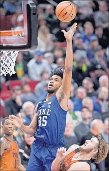  ?? [CRAIG MITCHELLDY­ER/THE ASSOCIATED PRESS] ?? INDIANA 87, EASTERN MICHIGAN 67: OHIO 96, MOUNT ST. MARY’S 77: ILLINOIS 86, NORTH CAROLINA CENTRAL 73: Duke freshman Marvin Bagley III shoots over Texas forward Dylan Osetkowski during Friday’s game in the Phil Knight Invitation­al tournament. Bagley...