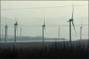  ??  ?? Windmills are seen from a high speed train traveling from Beijing to neighborin­g Zhangjiako­u in northweste­rn China’s Hebei province.