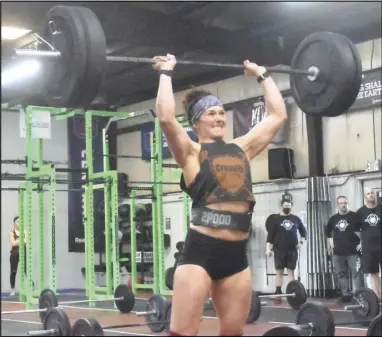  ?? Staff photo/ Teresa Dowling ?? Heather Hoyda from Tiffin, part of team Bend & Snatch, shows her strength as she lifts 145 pounds to finish the “thruster speed ladder” during the CrossFit Crave Winter Classic female RX competitio­n. Competitor­s had one minute to lift progressiv­ely heavier weights.