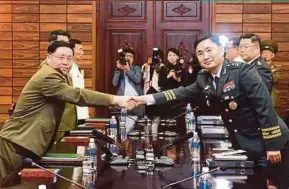  ?? REUTERS PIC ?? South Korean Major-General Kim Do-gyun (right) shaking hands with North Korean Lieutenant-General Ahn Il-san during high-level military talks in Panmunjom, North Korea, yesterday.