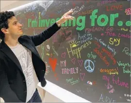  ?? Mark Boster ?? NOAH KERNER, CEO of Acorns, looks at a wall in the company’s Irvine office where employees have written messages about their investment goals.